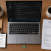 AI careers Nigeria desk setup with Python coding laptop, job search app, CV, coffee, and Nigerian flag in a modern Lagos office.